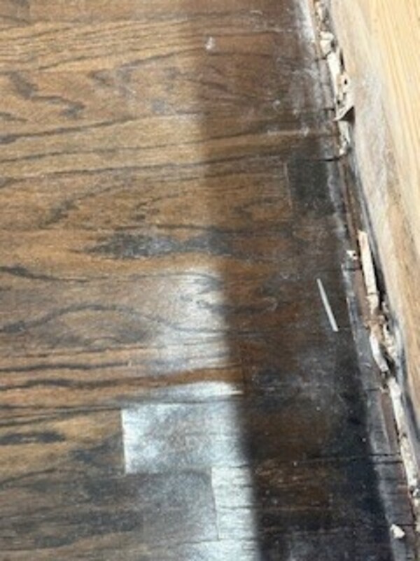 Close-up of wood-look flooring beside an exposed perimeter edge